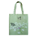 A light green rectangular tote bag features two swallowtail butterflies and their food plant milk-parsley, a plant with clusters of small white flowers
