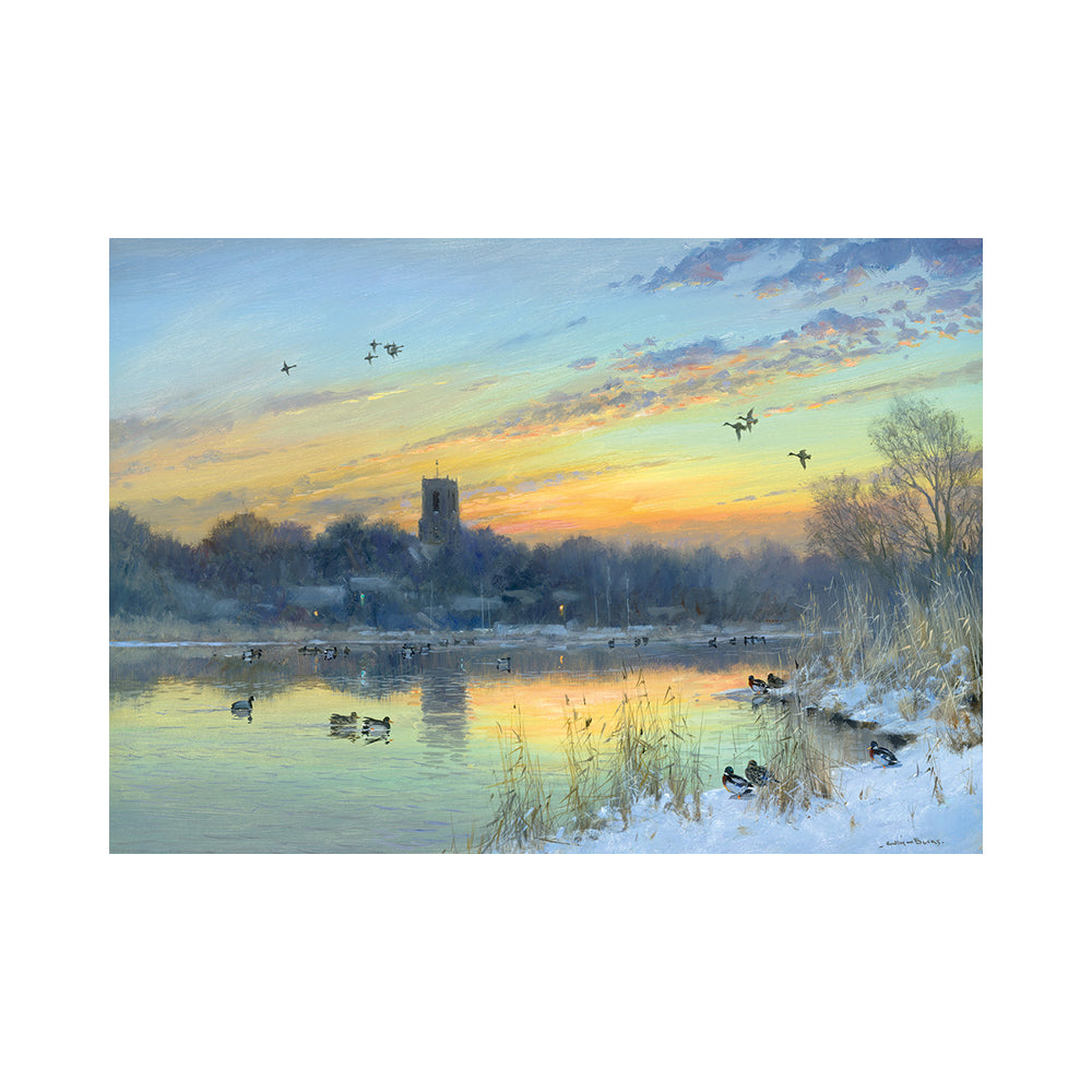 A view over Ranworth Broad full of ducks and other waterfowl, with geese flying overhead as the sun sets behind St Helen's church in the background, leaving an orange hue of a sunset echoed on the water of the broad.